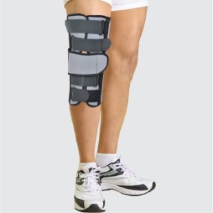 A person wearing a black and grey Dyna Knee Immobiliser 14"